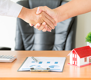 Side view hands of agent and client shaking hands after signed contract buy new apartment.