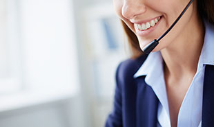 Toothy smile of young businesswoman with headset